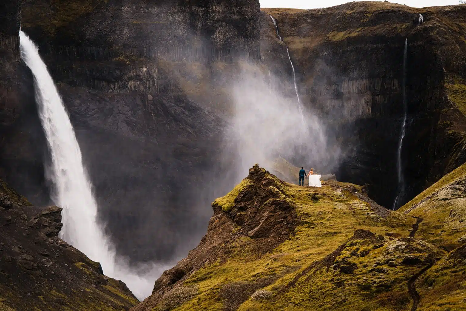 couple on wedding day staring at iceland waterfall