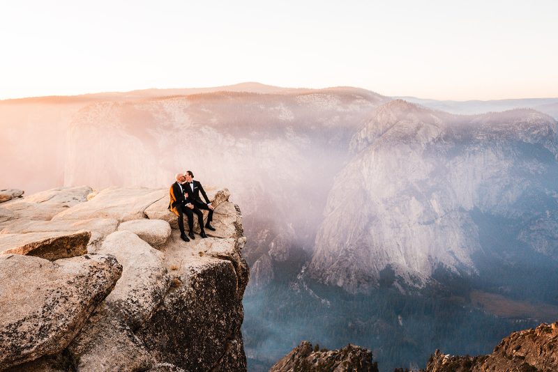 Wedding couple kissing on a boulder at Taft Point in Yosemite